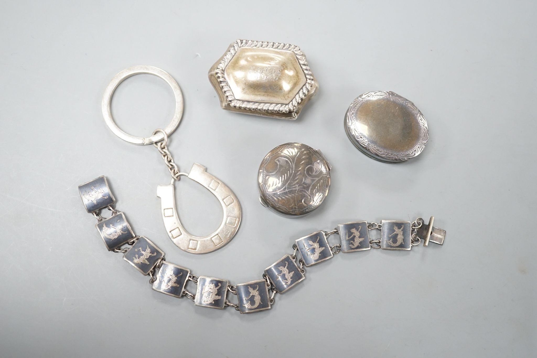 Three silver pill boxes, a key ring and white metal and niello bracelet.